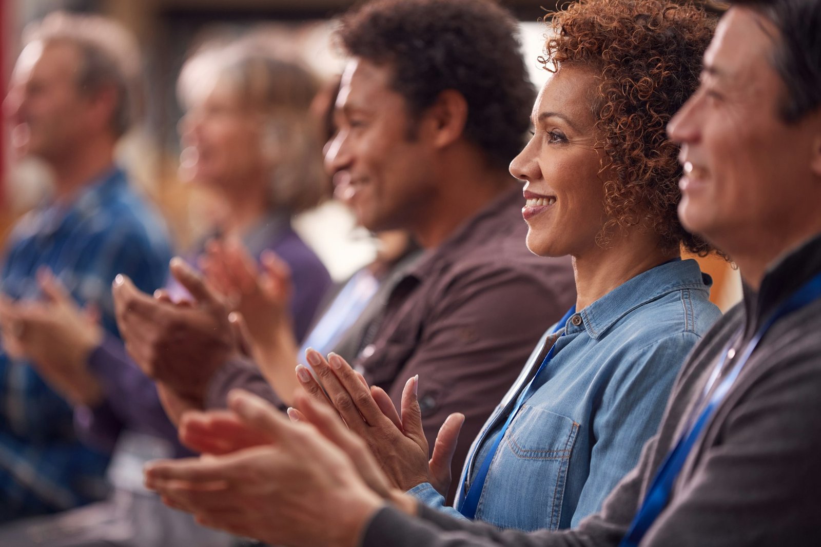 Group Of Casually Dressed Businessmen And Businesswomen Applauding Presentation At Conference